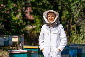 gut aussehend Mann Arbeiten Bienenzucht mit Bienenstock. Ernte Bienenwachs im sonnig Sommer. foto