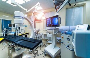 Betriebs Zimmer mit Röntgen medizinisch Scan. Klinik Innere mit Chirurgie Tisch, Lampen und Ultra modern Geräte, Technologie, Hi-Tech Innere, foto