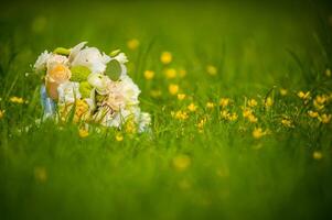 Blume Strauß von cremig Rosen auf Gras Über das verschwommen Hintergrund. Grün Gras und Blumen- Hochzeit Strauß mit schön Blumen. foto