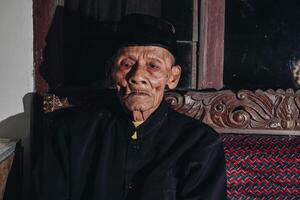 nachdenklich Senior asiatisch Mann Sitzung auf Zuhause Sofa, suchen Weg mit Gedanken, Denken Über Zukunft Ruhestand, Planung, träumend foto