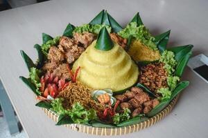 nasi Tumpeng, Java traditionell Essen isoliert auf Weiß Hintergrund. indonesisch rijsttafel von Gelb Reis mit Seite Geschirr von mehrere regional Küche im das Land zum Unabhängigkeit Feier. foto