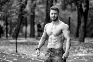 sportlich mit nacktem Oberkörper Mann Fitness Modell- posieren draussen im ein Sport Hof. nett muskulös Körper. Hälfte weist Foto. suchen zu das Kamera. Nahaufnahme. foto