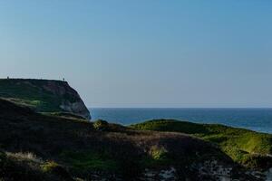 Küsten Landschaft mit Cliff und Meer unter ein klar Blau Himmel beim Dämmerung im Flamborough, England. foto