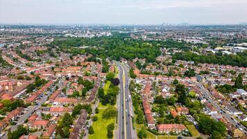 Antenne Aussicht von ein Vorort- Gegend mit Reihen von Häuser und ein zentral Straße, Bäume Beschichtung das Straßen, auf ein wolkig Tag im London. foto