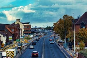 dramatisch Wolken Über städtisch Straße mit der Verkehr und Konstruktion Barrieren foto