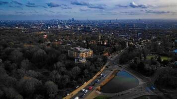 Antenne Aussicht von ein Stadt Horizont beim Dämmerung mit städtisch Park, Wasser Körper, und verstreut Wolken. foto