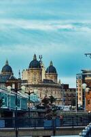 dramatisch Horizont mit historisch Gebäude und modern die Architektur unter ein wolkig Himmel. foto