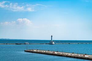 Aussicht von das Seebrücke zu das Meer auf das Hintergrund von das Leuchtturm im das Sommer. schön Landschaft foto