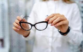 Brille Nahaufnahme. Brille im Frau Hände. präsentieren Brille. Zoomen In. foto