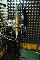 Fachmann Mikrofon hat befestigt zu Schock montieren und abgebildet im das Hintergrund von das Musik- Studio foto