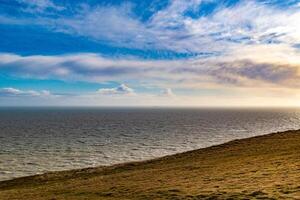 heiter Küsten Landschaft mit ein beschwingt Blau Himmel, flauschige Wolken, und Ruhe Meer, Ideal zum Hintergründe und Natur Themen. foto