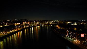 Nachtzeit Stadtbild mit beleuchtet Gebäude reflektieren auf ein Ruhe Fluss, präsentieren städtisch Schönheit und Ruhe im Newcastle auf tyne foto