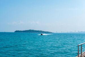 Seelandschaft mit Geschwindigkeit Boote Kommen zu das Seebrücke, zurück Aussicht von Pattaya Stadt, Thailand foto