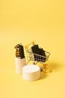 Leeres Mock-Podium oder Podest und Miniatur-Supermarktwagen mit Einkaufstüten im schwarzen Freitagsverkauf auf Gelb foto