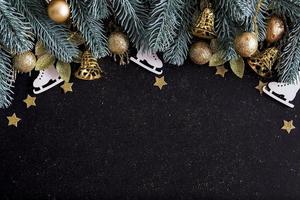 Draufsicht Frohe Weihnachten schwarzer Hintergrund dekoriert mit Frohes neues Jahr Weihnachtsbaum Zweige, Sterne, Glocken und Kugeln mit Kopierraum. Winterurlaub Kartendekoration festliches Spaßkonzept, flache Lage. foto