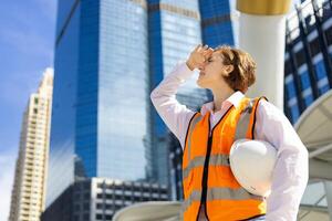 kaukasisch Frau Ingenieur ist suchen Über das Hochhaus Gebäude während inspizieren das Konstruktion Projekt zum modern die Architektur und echt Nachlass Entwicklung foto