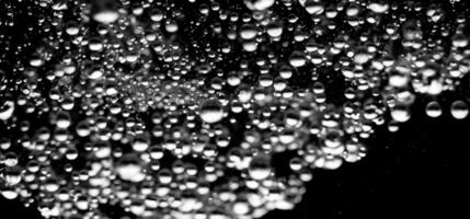 ai generiert Limonade Wasser Luftblasen planschen unter Wasser gegen schwarz Hintergrund. foto