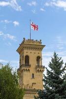 Georgia Flagge auf das Dach von ein uralt Turm gegen das klar Blau Himmel foto