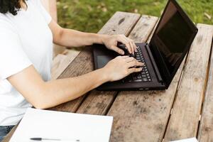 Hände einer Person, die einen Laptop benutzt. foto