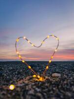 Herz Symbol mit hell Fee Beleuchtung auf das Strand foto