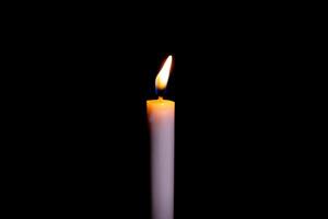 Verbrennung Weiß Kerze auf das dunkel, Flamme von Kerze auf schwarz Hintergrund foto