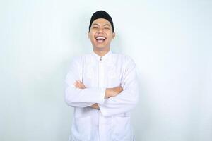 asiatisch Muslim Mann Lachen mit gefaltet Arm isoliert auf Weiß Hintergrund foto