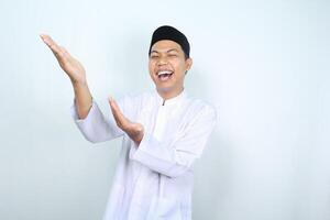 Porträt von Lachen asiatisch Muslim Mann präsentieren zu Seite isoliert auf Weiß Hintergrund foto