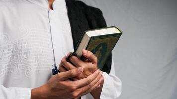 Mann halten das Koran mit Gebet Perlen im seine Hand foto