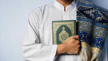 Muslim Mann Tragen ein Koran und Gebet Matte foto