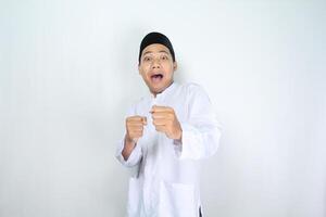 komisch Muslim Mann asiatisch sieht aus überrascht und Show Kampf Geste isoliert auf Weiß Hintergrund foto