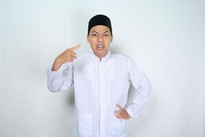 wütend Muslim asiatisch Mann zeigen zu ihm selbst isoliert auf Weiß Hintergrund foto