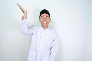 attraktiv Muslim asiatisch Mann präsentieren Hand zu über mit lächelnd Gesicht isoliert auf Weiß Hintergrund, suchen beim Kamera foto