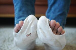 Männer Füße mit schmutzig Socken während Sitzung auf Sofa foto