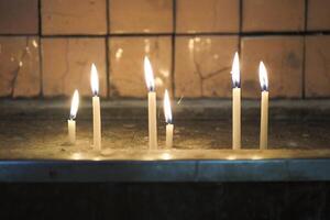 Reihe von Verbrennung Kerzen im ein Kirche. foto