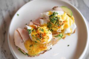 Eier Benedikt mit Schinken auf ein Platte. köstlich Frühstück. foto