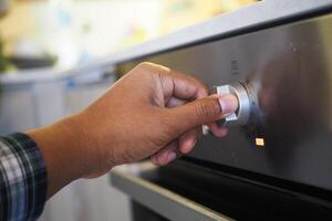 schließen oben von Männer Hand Rahmen Temperatur Steuerung auf Ofen. foto