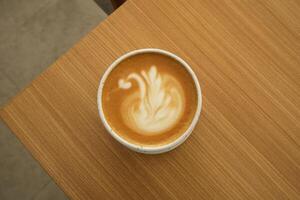 eine tasse heißen latte kaffee auf dem tisch zum frühstück foto