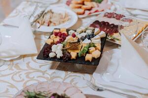 ein Aussicht von Hochzeit Tische, Beachtung zu Portion, mit Blume Arrangements, teuer Besteck, Platten mit Weiß Servietten. foto