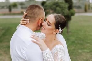 das Braut und Bräutigam umarmen. das Braut sanft Umarmungen das Bräutigam durch das Schultern. schön Hochzeit Paar. das Konzept von Romantik im ein Jungvermählten Beziehung. Flitterwochen. foto