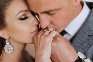 Hochzeit Kuss. Bräutigam Küsse Braut Hand. hochzeit Liebe. Nahansicht von ein jung Mann küssen seine Ehefrauen Hand mit Gold Ring während Herstellung ein Ehe Vorschlag. foto