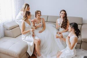 Foto Braut mit ihr freunde Trinken Champagner von Brille. abgeschnitten Schuss von ein schön jung Braut und ihr Brautjungfern haben Champagner Vor das Hochzeit.