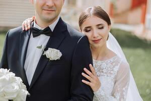 das Braut und Bräutigam umarmen. das Braut sanft Umarmungen das Bräutigam durch das Schultern. schön Hochzeit Paar. das Konzept von Romantik im ein Jungvermählten Beziehung. Flitterwochen. foto