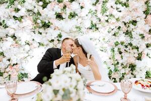 gestohlen Momente beim ihr Hochzeit Rezeption. jung Hochzeit Paar erziehen Champagner Brille während Hochzeit Feier foto