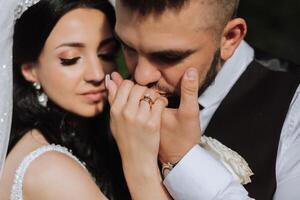 Hochzeit Kuss. Bräutigam Küsse Braut Hand. hochzeit Liebe. Nahansicht von ein jung Mann küssen seine Ehefrauen Hand mit Gold Ring während Herstellung ein Ehe Vorschlag. foto