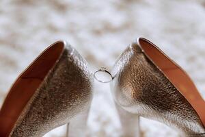 Braut Schuhe. das Mädchen trägt Stilettos. elegant Damen Schuhe. schön Einzelheiten. das Braut setzt auf ihr Schuhe und bereitet vor zum das Hochzeit Zeremonie foto