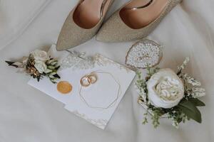 Braut Engagement Ring, Stilettos, Parfüm. Hochzeit Einzelheiten von das Braut. Blumen schön Licht. Hochzeit Kleid foto