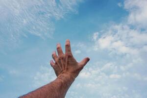 Mann Hand gestikulieren auf das Blau Himmel foto