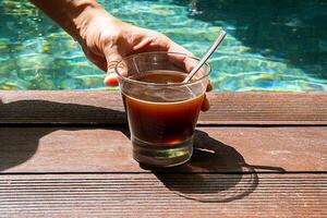 Frau Trinken Kaffee im das Schwimmen Schwimmbad. Morgen Kaffee beim am Pool. foto