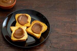 Toast mit Dulce de leche auf ein schwarz Platte, typisch Argentinien Snack. foto