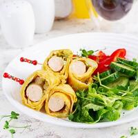 ketogen Frühstück. Omelette mit Wurst. Würstchen rollen im Omelette mit Lavasch. Keto, ketogen Mittagessen. foto